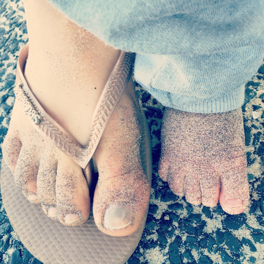 Mum and baby feet next to each other with sandy toes
