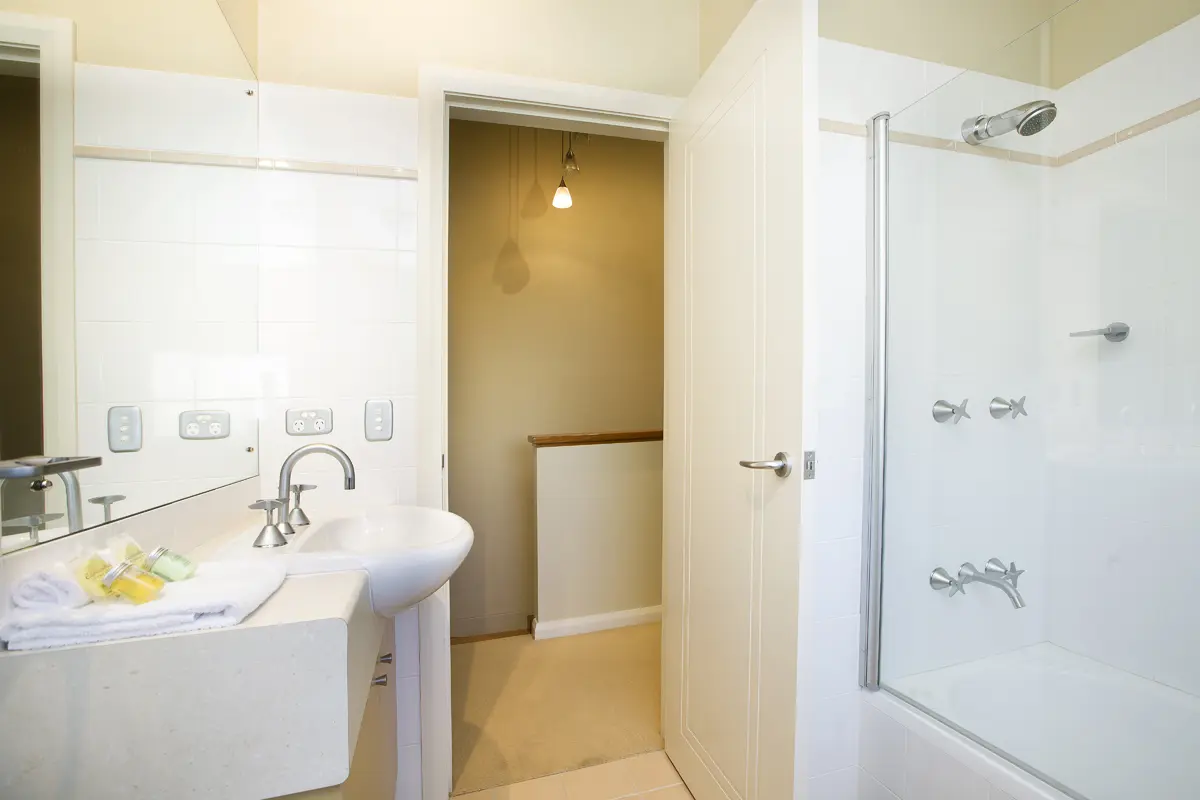 Main bathroom with bath and shower in a Two Bedroom Townhouse at Blueys Retreat