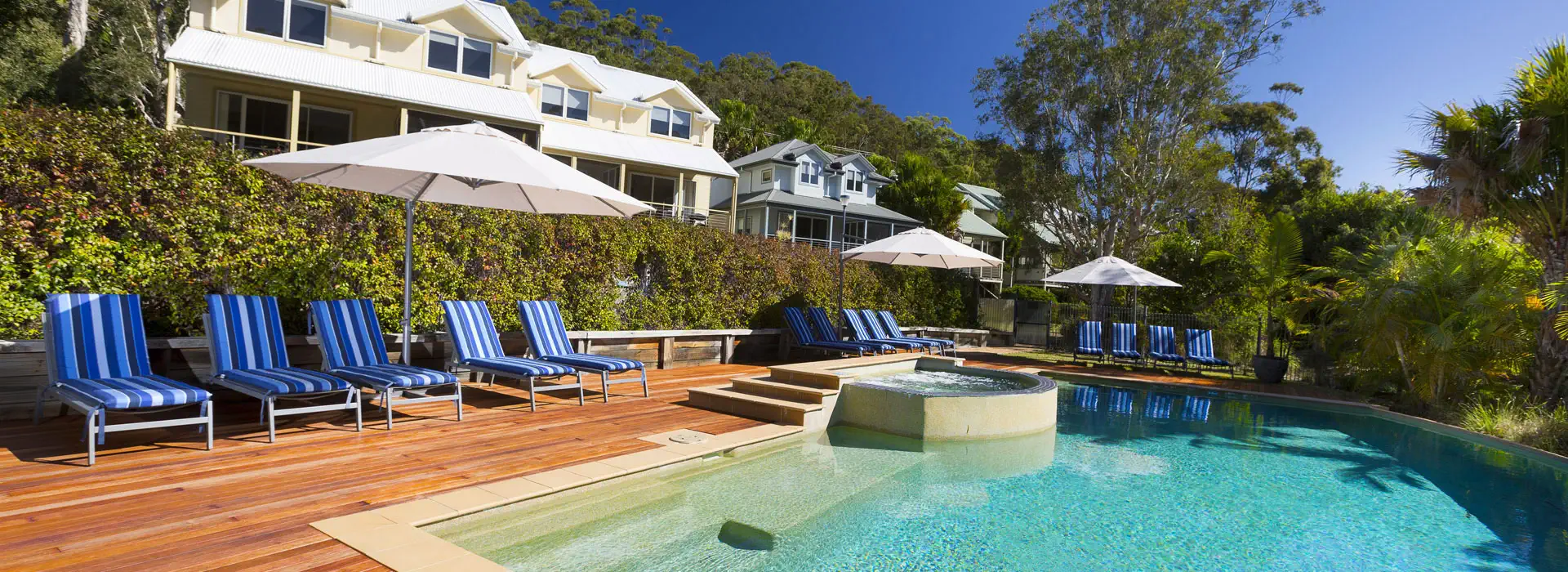 Outdoor swimming pool and spa with villas at Blueys Retreat
